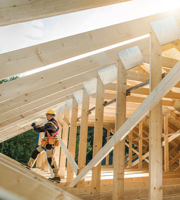Zimmermann arbeitet an einem neu gebauten Dachstuhl